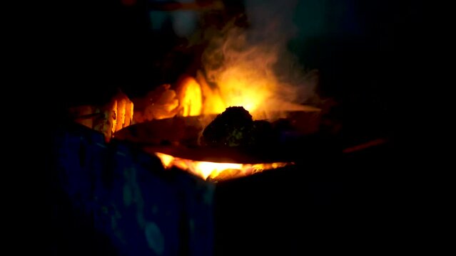 Top down shot meat patties being cooked on coal wood fire street food in cold winters of delhi as snack