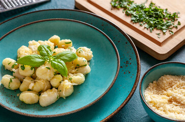Traditional homemade cooked italian potato gnocchi with butter, parsley and parmesan cheese on background