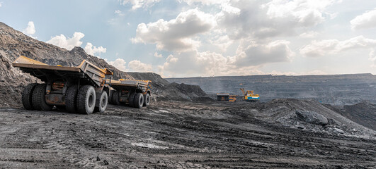 Panoramic view of coal mine. Open pit mine industry, big yellow mining truck for coal quarry. Open...