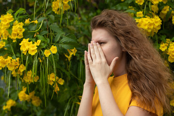 Portrait of beautiful young allergic woman is suffering from pollen allergy or cold on natural...