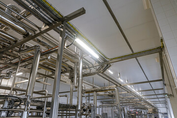 Galvanized round ventilation air and gas ducts in an industrial building. Engineering air system on a metal frame.