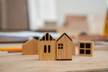 Model of two wooden houses among wooden houses in the background Real estate business concept and real estate agents