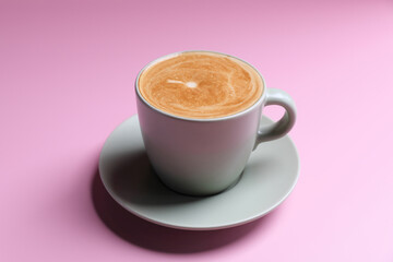hot cappuccino with latte art isolated in pink background