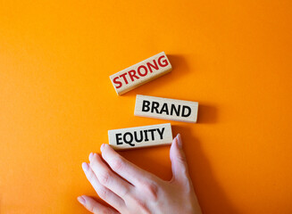 Strong Brand Equity symbol. Concept words Strong Brand Equity on wooden blocks. Businessman hand....
