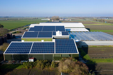 Flower bulb company with solar panels in a row on a roof. Photo taken with a drone.
Photovoltaic...