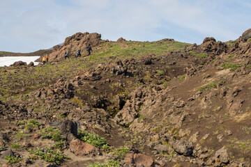 Summer mountain landscape. Hikers climb the rocky slope of the volcano. Travel, tourism and hiking on the Kamchatka Peninsula. Nature of Siberia and the Russian Far East. Kamchatka Territory, Russia.