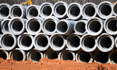 Concrete drainage pipes lined up a construction site ready to be installed.