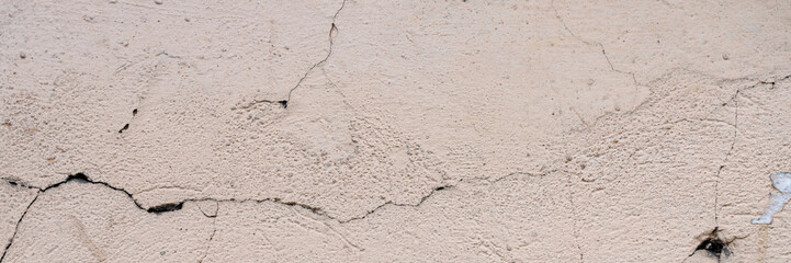 Obraz premium Old wall with cracked plaster. Weathered rough surface. Wide panoramic texture for background and design.