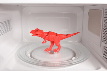 Toy tyrannosaurus rex inside a microwave oven close-up
