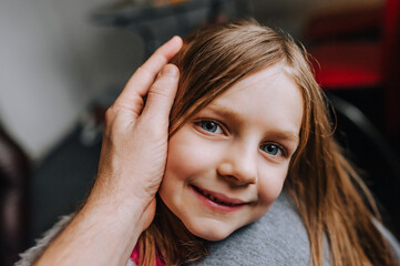 Close-up portrait of a beautiful red-haired long-haired girl's face, a child, a daughter and a...