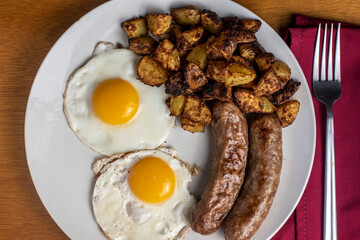 two eggs with homefries and  sweet italian sauage