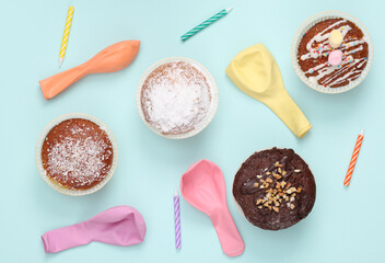 Happy birthday concept. Cupcake with candles and air balloons on blue background. Top view