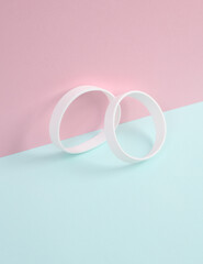 White silicone bracelets on a blue-pink pastel background