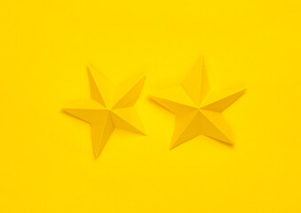 Fototapeta premium Two paper stars on yellow background. Service rating