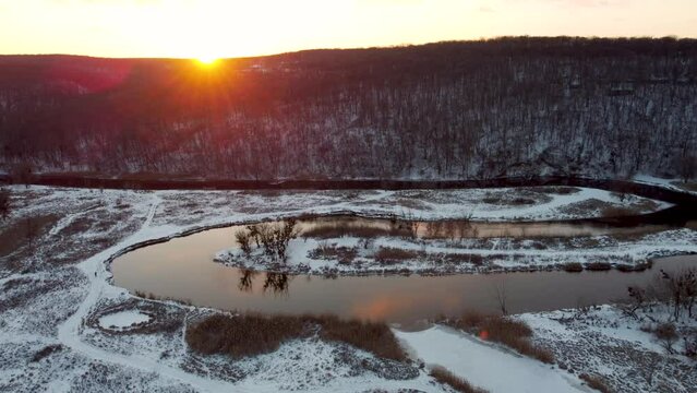 Aerial sunset on river curve with scenic reflection in winter. Zmiyevsky region on Siverskyi Donets river valley in Ukraine