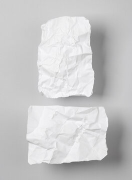 White crumpled piece of papers on gray background