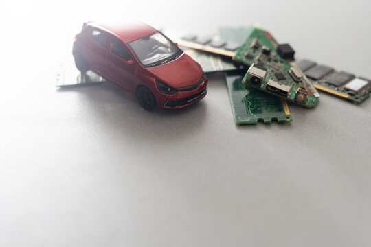 Toy Cars On An Electronic Board With Integrated Circuits. The Shortage Of Microchips And Semiconductors Creates A Shortage Of New Cars. Semiconductor Shortage Concept.