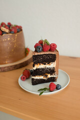A piece of cake decorated with berries on a plate