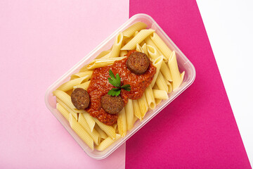 Macaroni with tomato sauce, chorizo and cheese in plastic container