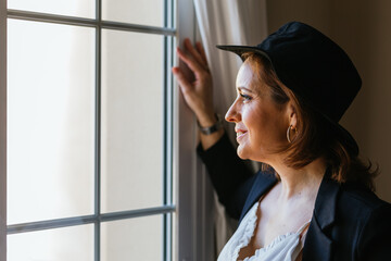 Close-up view of a woman while looking out window standing at home.