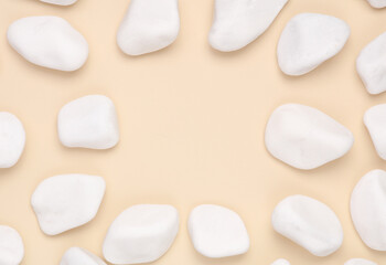 Fototapeta na wymiar White pebbles on beige background. Copy space