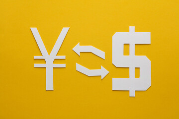 Fototapeta premium Currency exchange. Paper cut yuan and dollar symbol with exchange arrows on yellow background