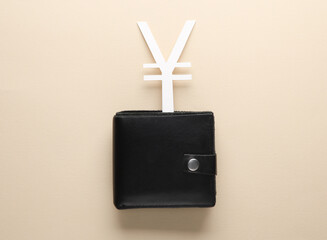 Purse and yuan currency symbol on beige background