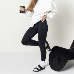 Woman in black leggings and white rubber slippers. Casual style. Square