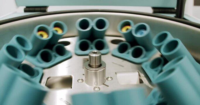 Centrifuge machine with vials in laboratory. From above centrifuge machine with test tubes spinning then stopping during workday in modern lab.