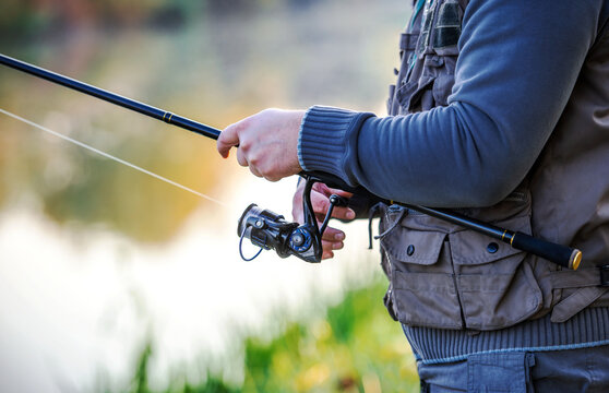 Fisherman angling on the river, close up photo. Sport and recreation concept