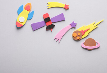 Handmade, children's art. Rocket, with comets and satellit on gray background. Space exploration....