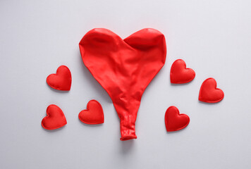 Red balloon in the shape of a heart with hearts on a gray background. Love concept