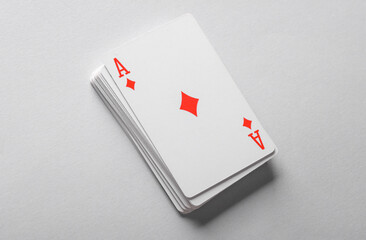 Ace of diamonds on a stack of playing cards, gray background