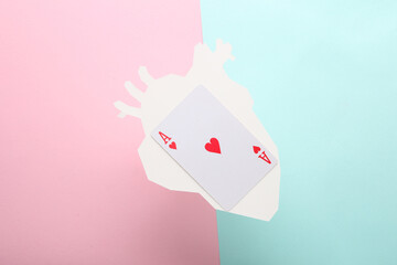 Paper-cut heart with ace of hearts card on blue-pink pastel background