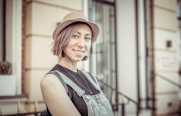 Fototapeta premium Portrait of a young stylish Caucasian woman in hat in city