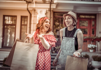 Two Emotional female friend have a shopping in the city. Attractive girls with shopping bags