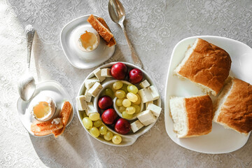 Soft boiled eggs, fruit and wheat bread for breakfast