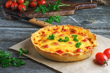Quiche lauren - cheese vegetable pie with chicken on a wooden table