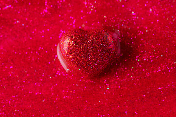 Sparkle bright heart on glitter and shine red background.