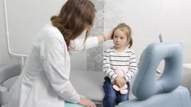 Sad little girl with a toy in the office of a child psychologist.