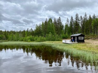 Cozy wooden fisher house at the lake, no people, lake in the forest