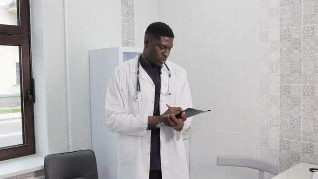 A picture of a handsome young doctor standing alone in his clinic