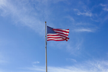 united states flag on a blue background with clouds on a flagpole