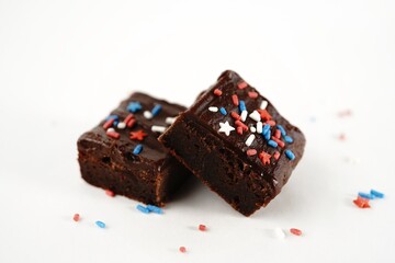 Chocolate fudge brownies with patriotic red blue white sprinkles on white background