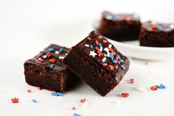Chocolate fudge brownies with patriotic red blue white sprinkles on white background