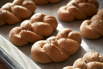 Freshly baked braided bread buns made from whole grain spelt flour