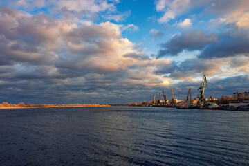 Scenic view of riverport with cranes under picturesque sunset sky. Dnieper river, Cherkasy, Ukraine