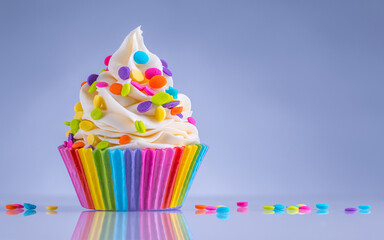 Cupcake. Happy Birthday. Tasty birthday cupcake with white cream icing and rainbow sprinkles. Sweet...