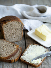 Rye bread and some butter to spread on the slices. Close up. Vertical, rustic