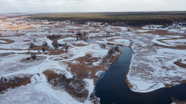 Winter aerial scenic view on snowy river valley from flying forward drone. Zmiyevsky region on Siverskyi Donets River in Ukraine